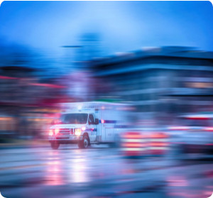 Ambulanz fährt bei Regen in der Nacht